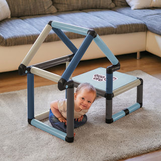 Child sitting inside a playhouse and climbing frame