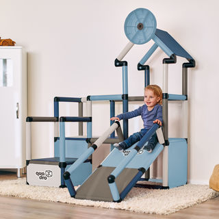 Child sliding on play house climbing frame